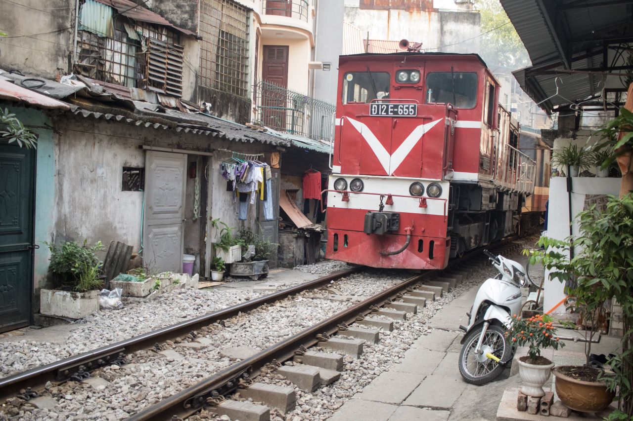 Vlak prechádzajúci tesnými uličkami Hanoja